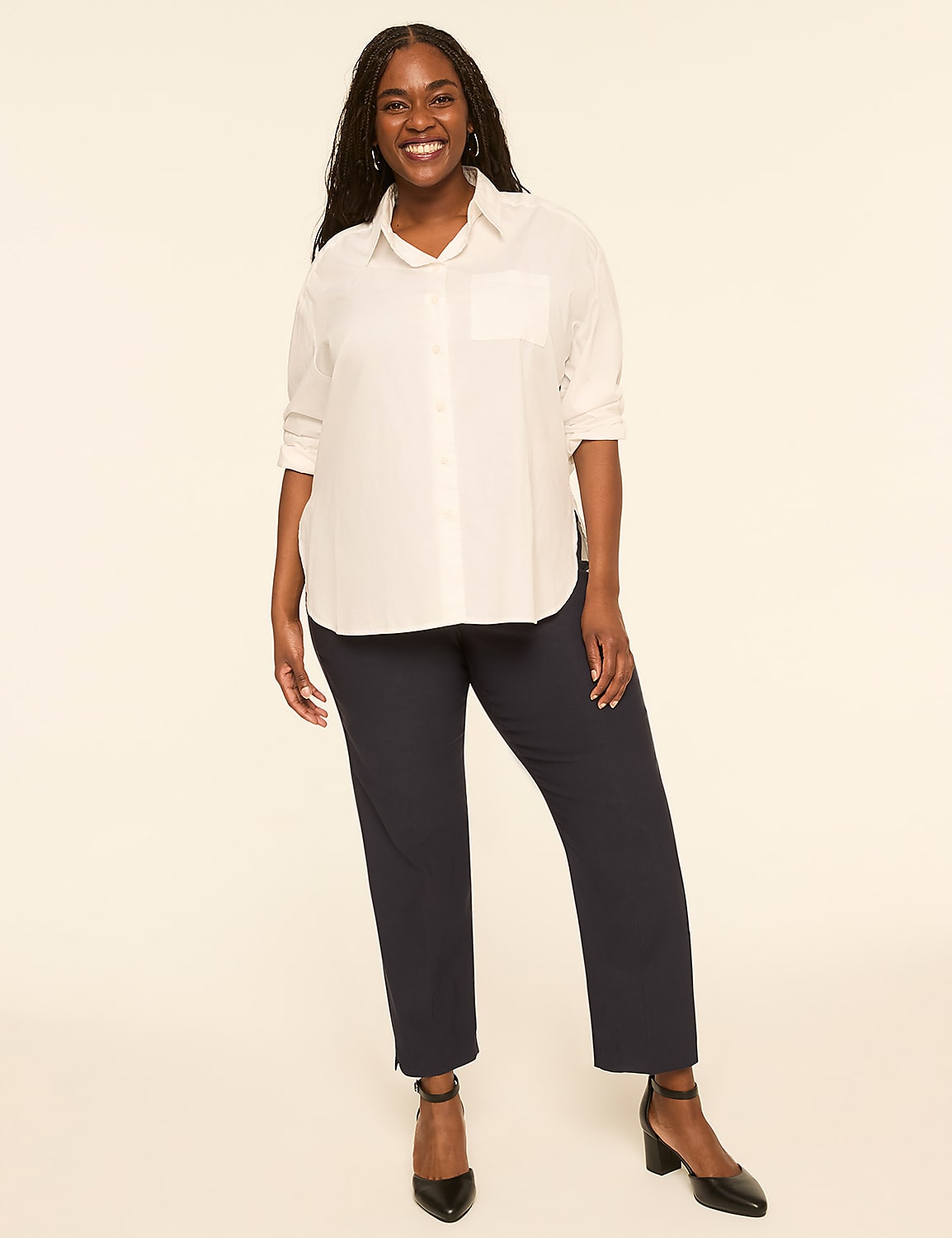 A smiling woman in a white button-down shirt and dark pants stands against a plain, light-colored background. Product Image 3