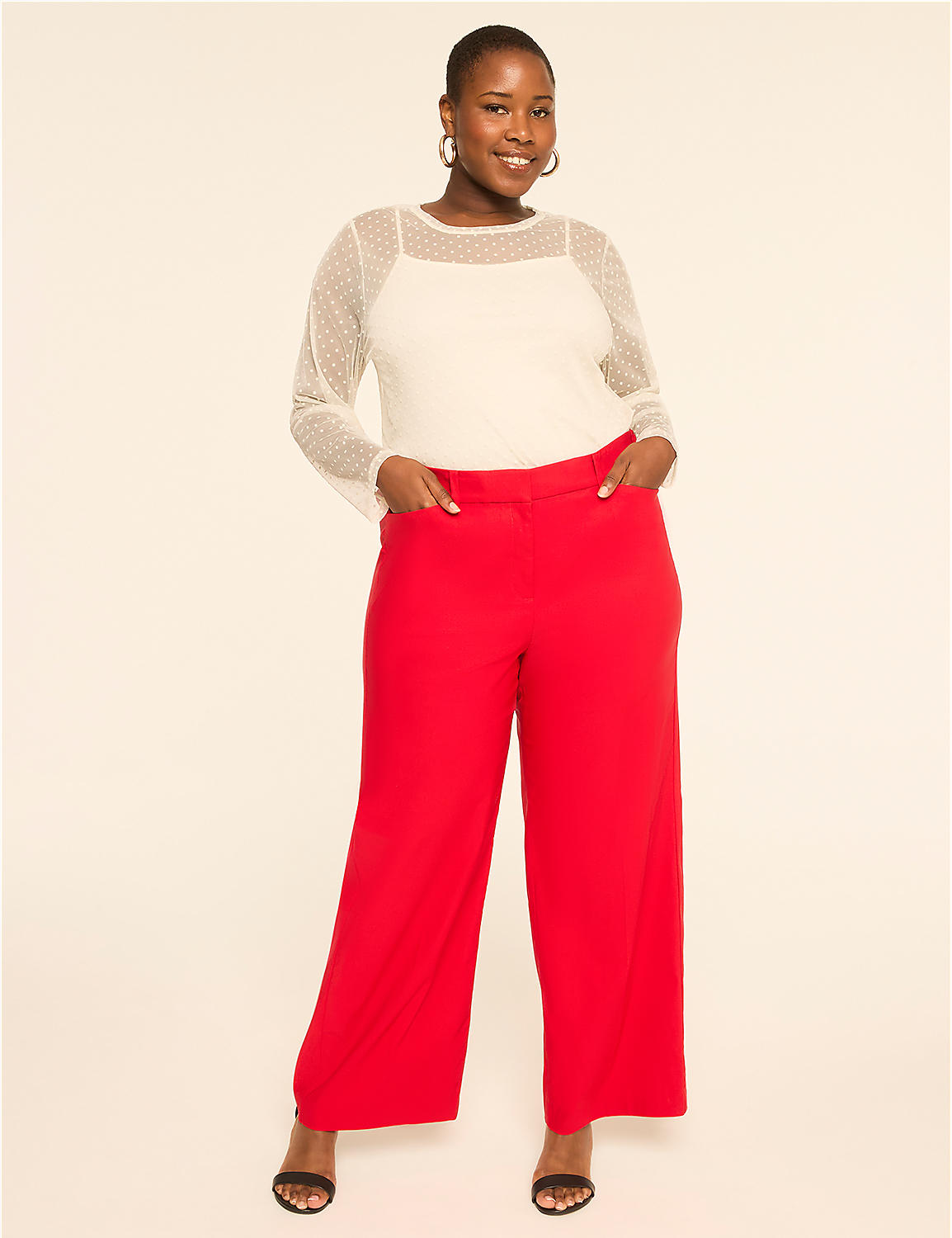 A smiling woman in a white sheer-sleeved top and red wide-leg pants stands against a plain, light-colored background. Product Image 3