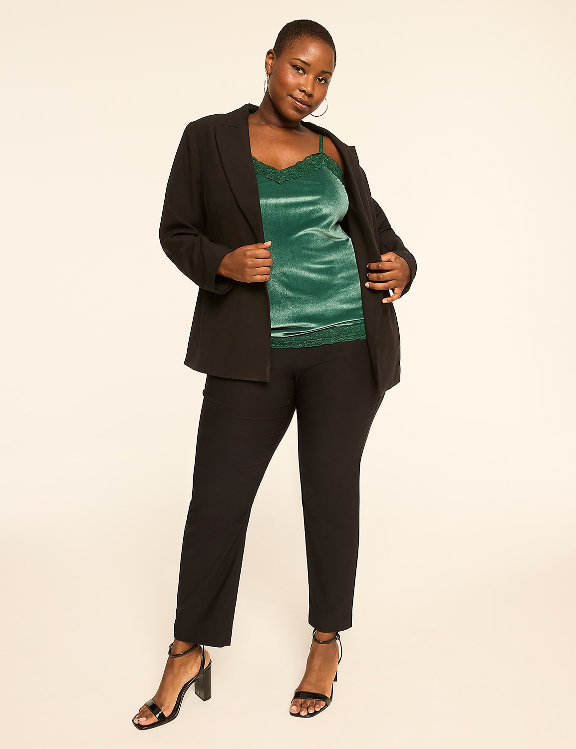 A woman in a black blazer, green velvet camisole, and black pants stands against a plain, light-colored background. Product Image 3