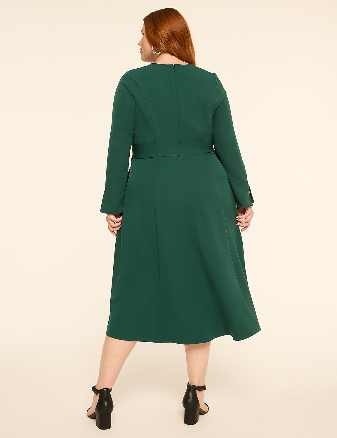 A woman in a green dress stands against a plain, light-colored background. Product Image 2
