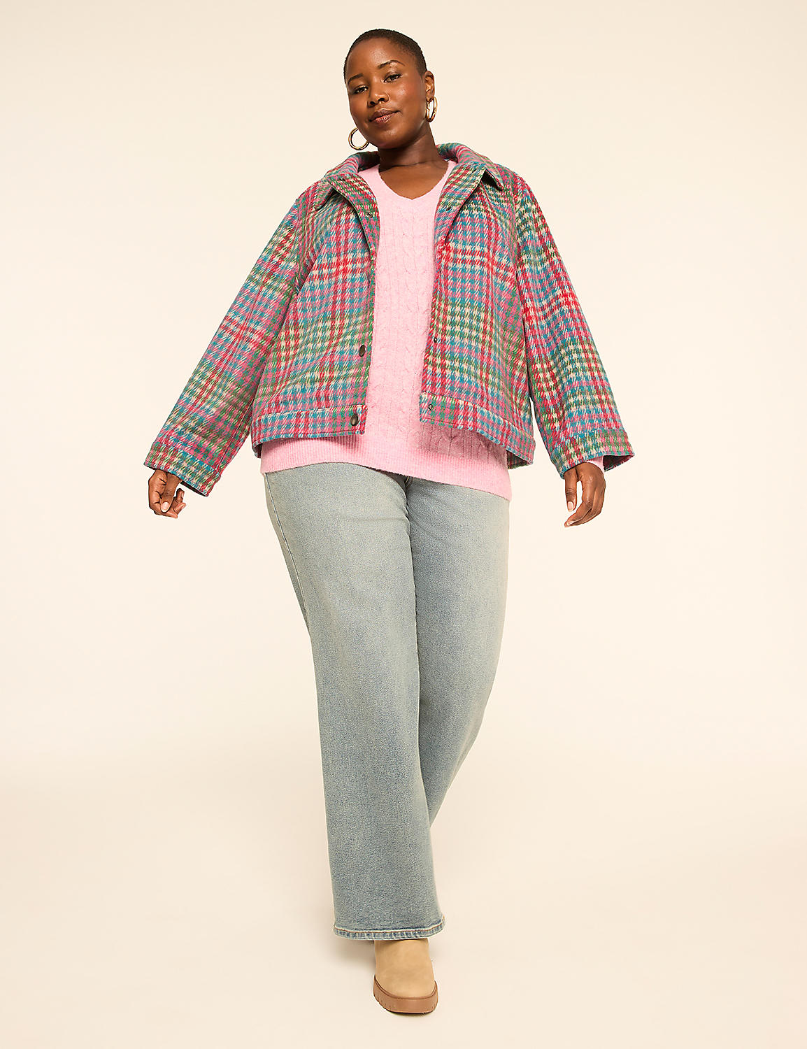 A woman in a pink sweater and light blue jeans stands against a plain, light-colored background, wearing a colorful plaid jacket. Product Image 3