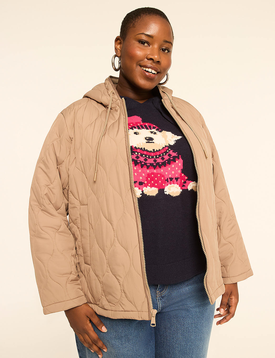 A woman in a quilted tan jacket and a navy sweater with a polar bear design smiles against a plain, light background. Product Image 1