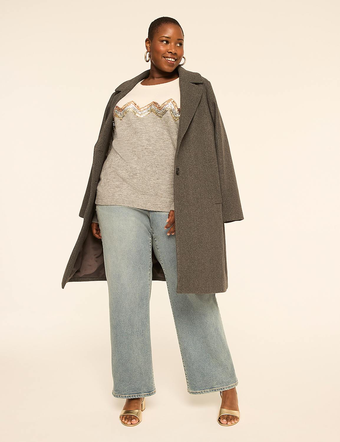 A woman in a grey coat, embellished sweater, and light wash jeans stands against a plain, light-colored background. Product Image 3