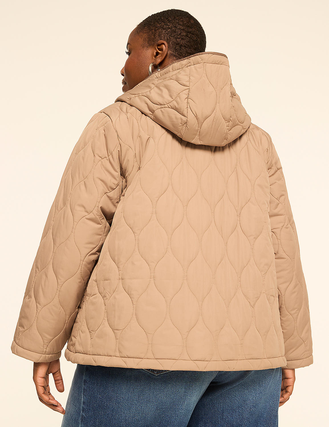 A woman in a tan quilted jacket and blue jeans stands against a plain, light-colored background. Product Image 2