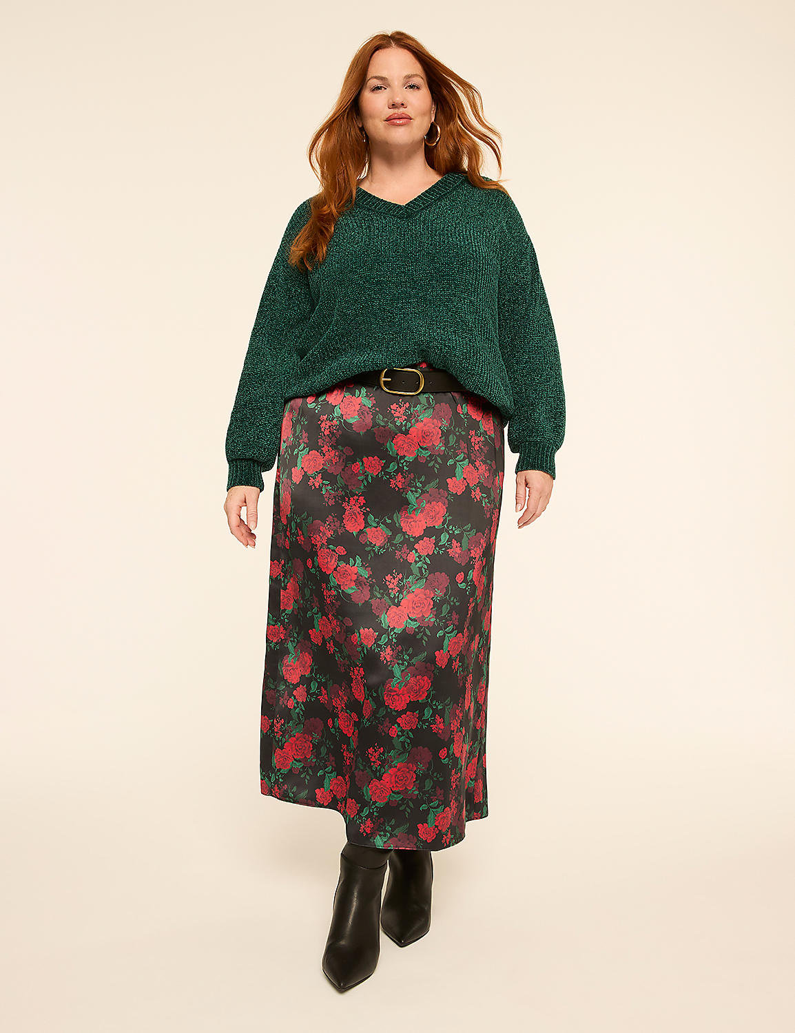 A woman with red hair stands in the foreground wearing a green sparkly sweater and a floral skirt, against a plain cream background. Product Image 3