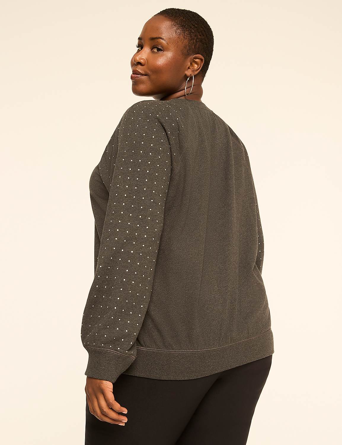 A woman in a dark, textured sweater with silver polka dots on the sleeves stands against a plain, light-colored background. Product Image 2