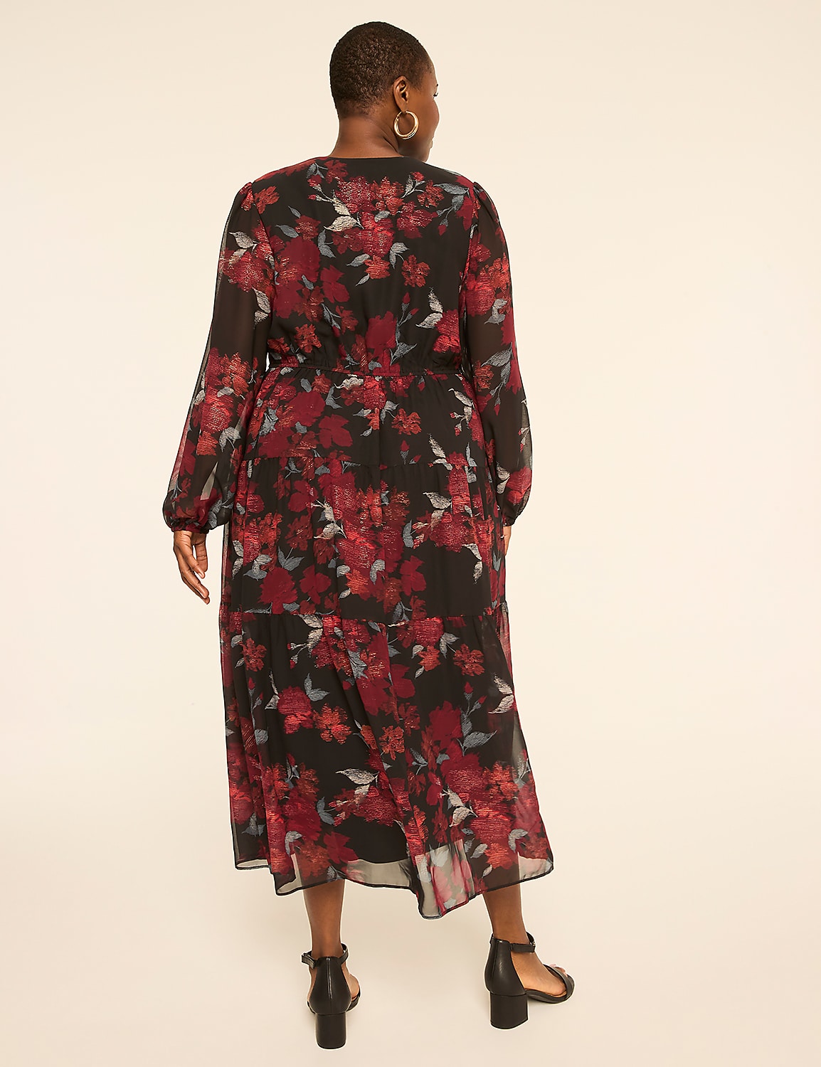 A woman in a floral print dress stands against a plain, light-colored background. Product Image 2