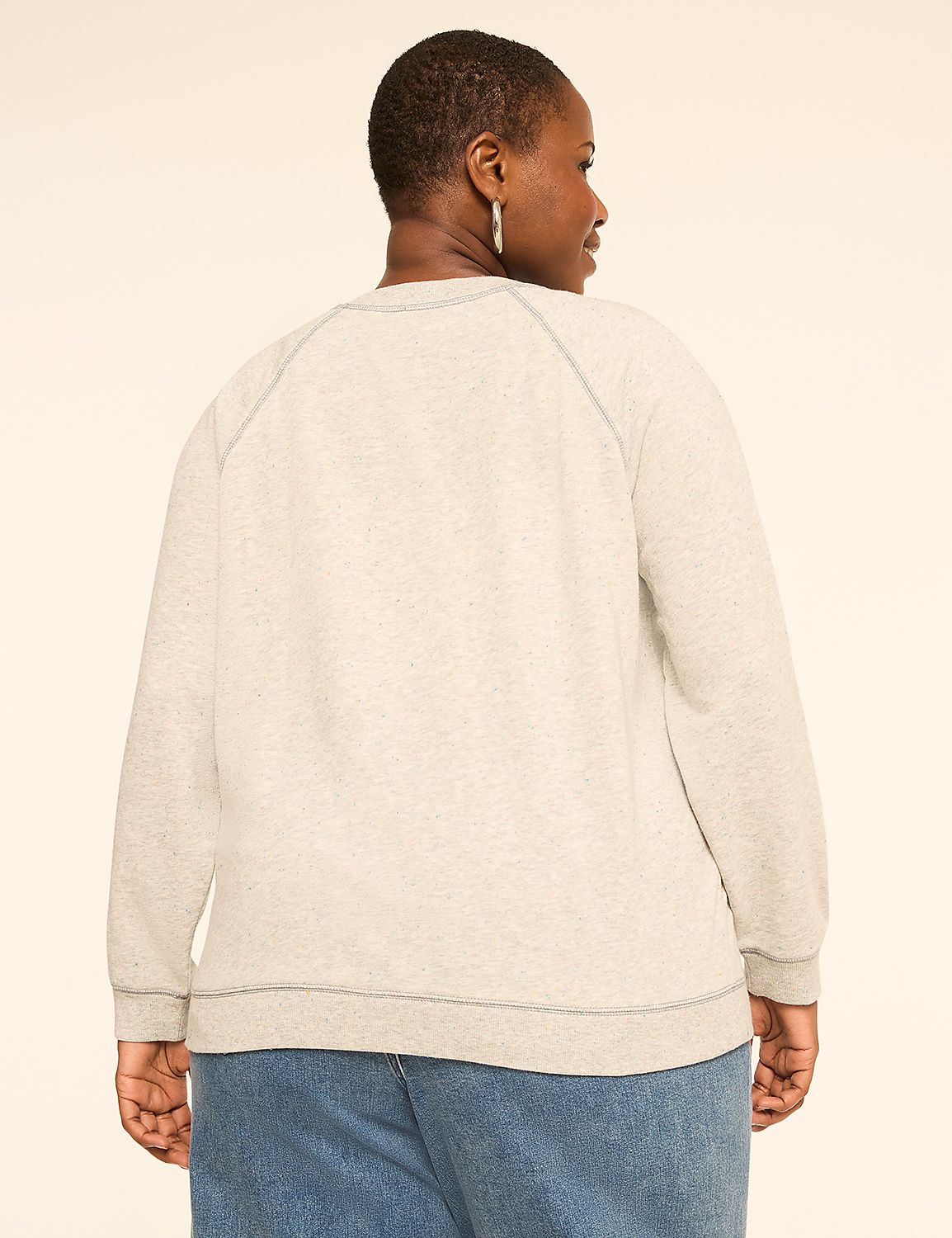 A woman in a light gray sweatshirt and blue jeans stands against a plain, light-colored background. Product Image 2
