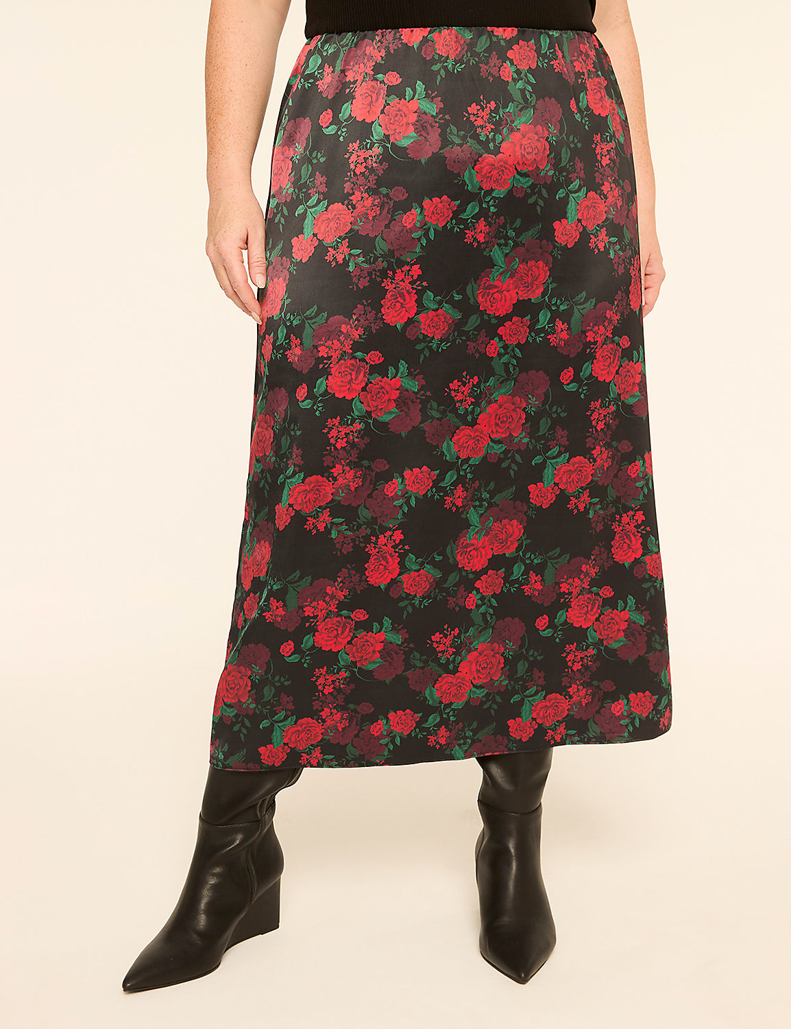 A person stands wearing a black skirt with a red rose pattern and black boots against a plain, light-colored background. Product Image 1