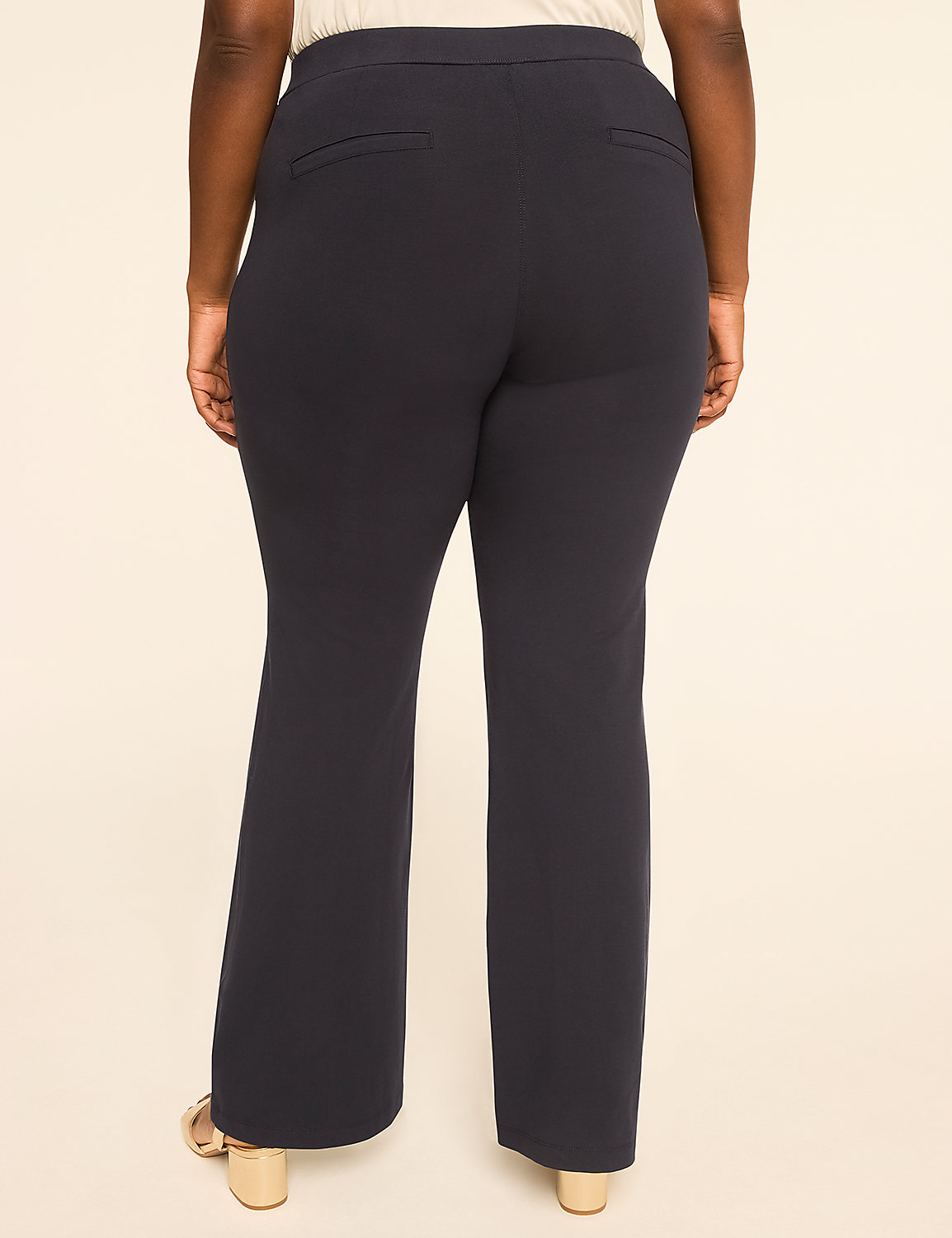 A person wearing dark blue flared pants stands against a plain, light-colored background. Product Image 2