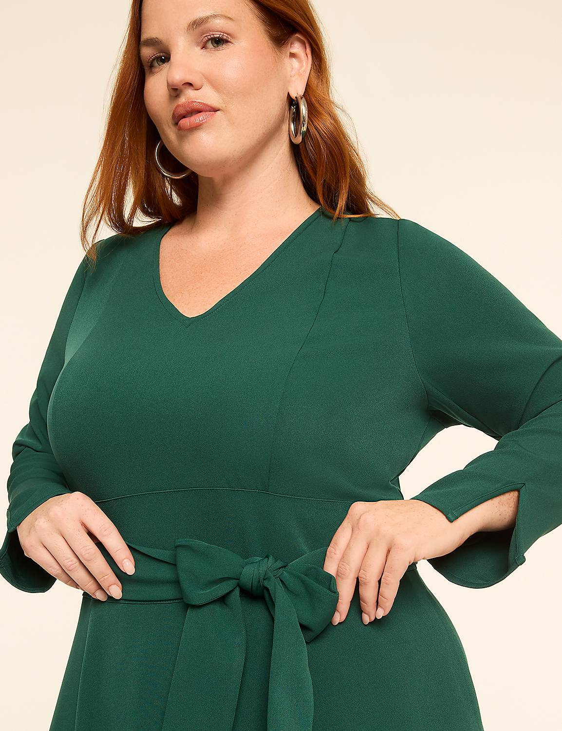 A woman in a green dress with a bow at the waist poses against a plain background. Product Image 3
