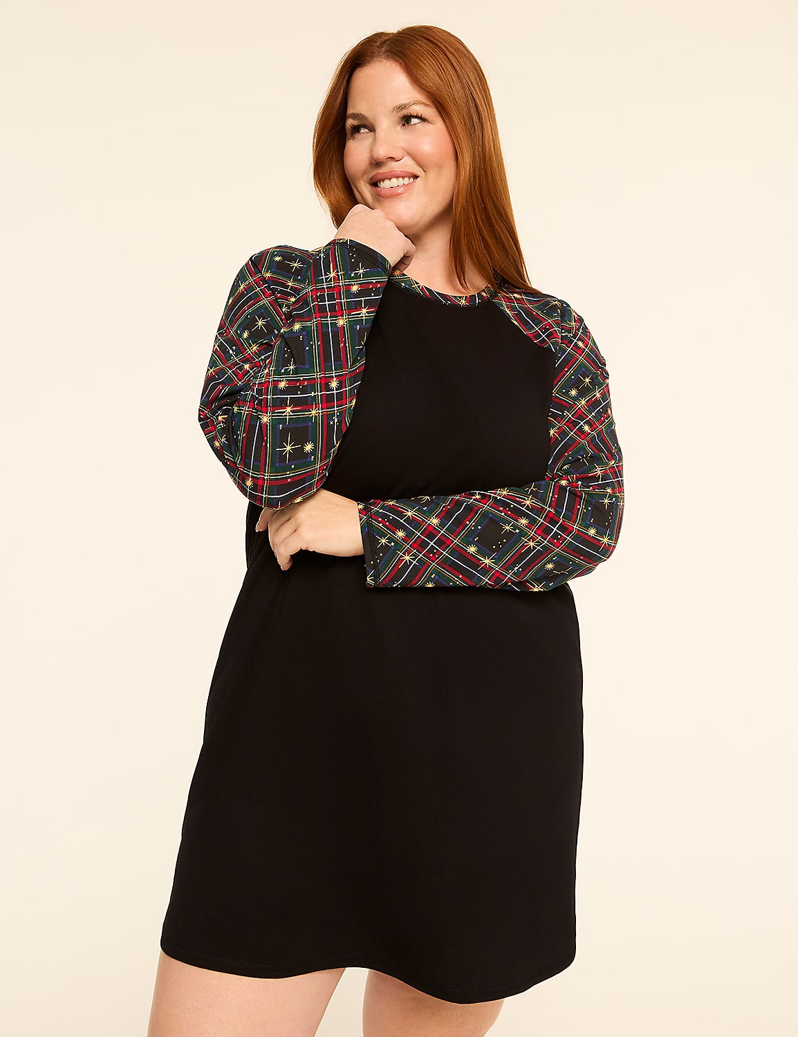 A smiling woman with red hair poses in a black dress with plaid sleeves against a plain, light-colored background. Product Image 1