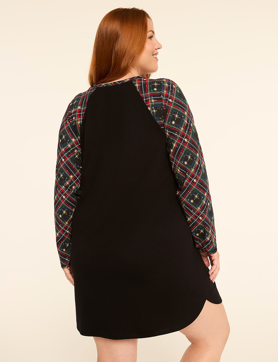 A woman with red hair stands facing away from the camera, wearing a black dress with plaid sleeves, against a plain, light-colored background. Product Image 2