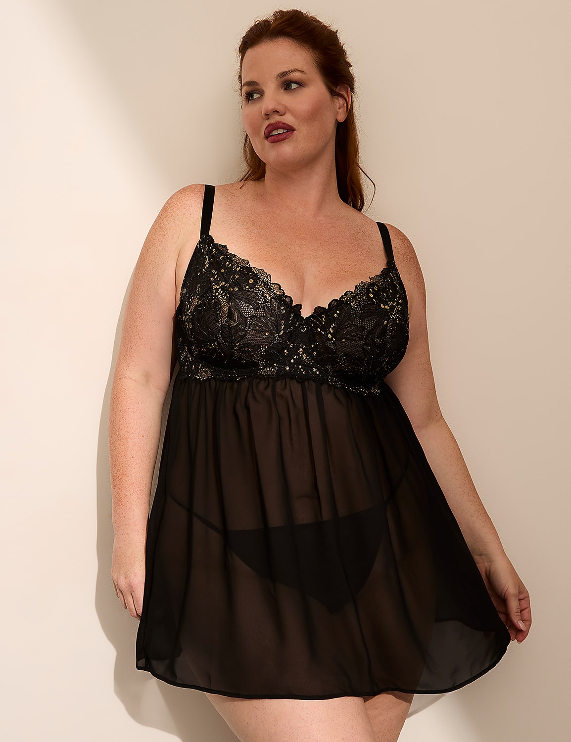 A woman in a black lace babydoll stands against a plain, light-colored wall. Product Image 1