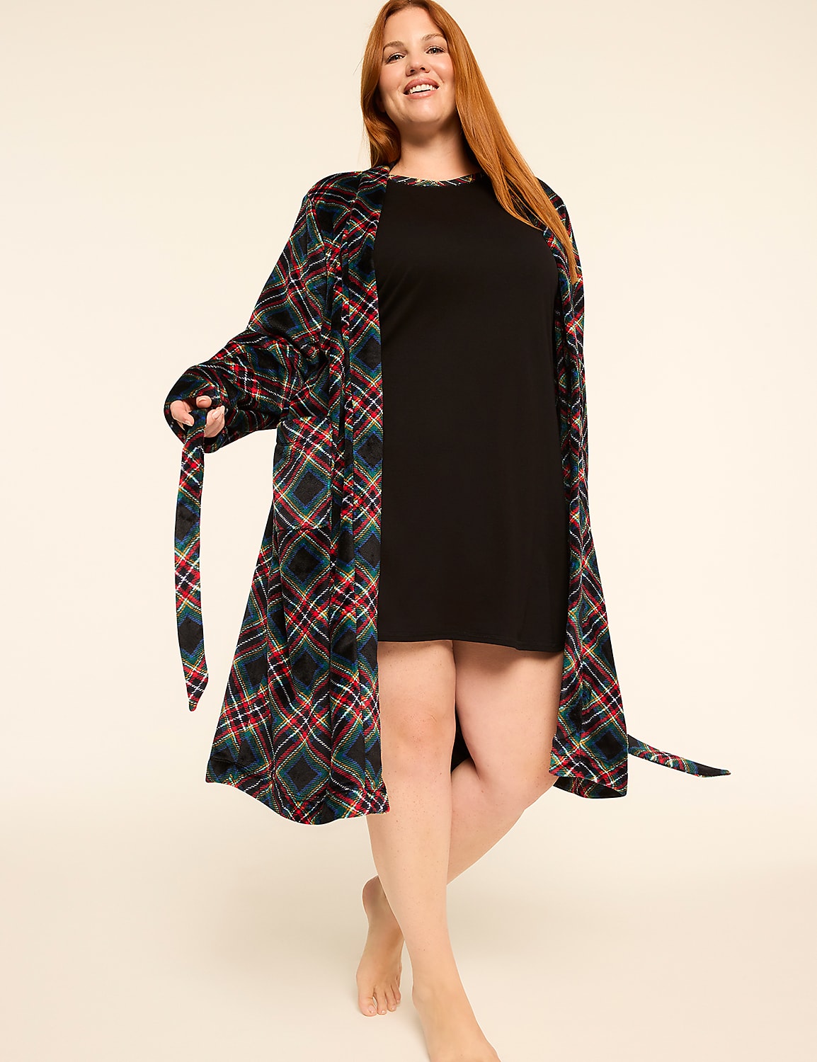A smiling woman with red hair stands barefoot in a black dress and a plaid robe against a plain, light background. Product Image 3