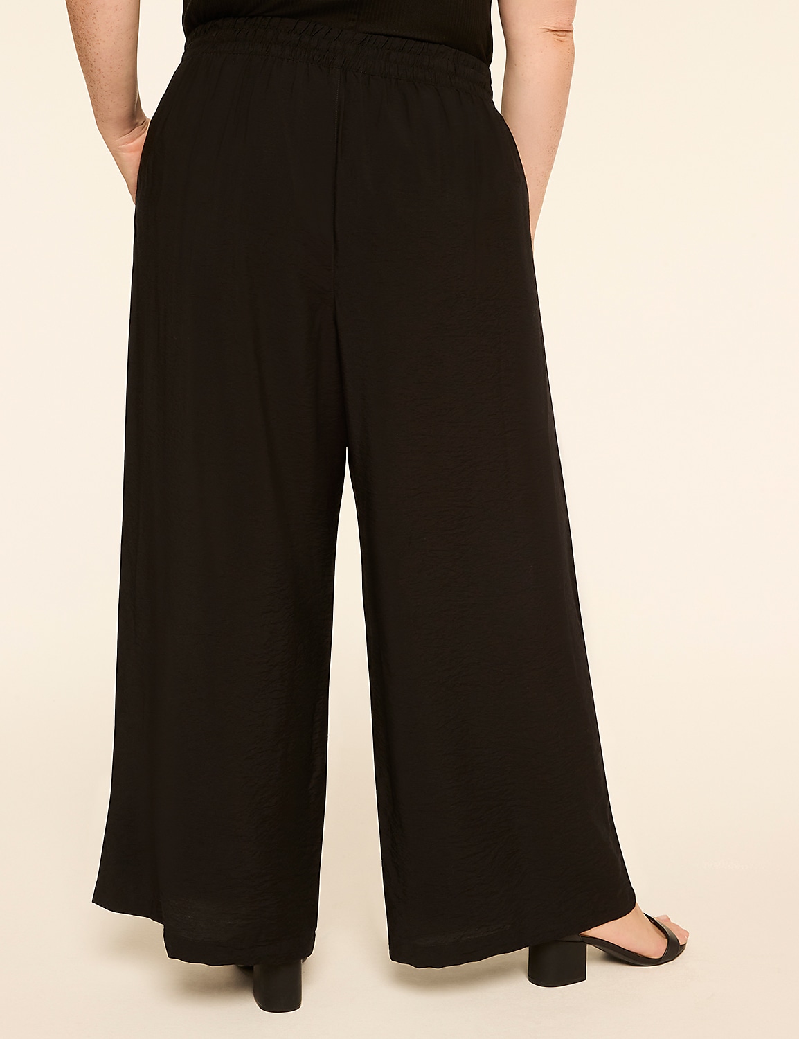 A person wearing black wide-leg pants with their hands in their pockets stands against a plain, light-colored background. Product Image 2