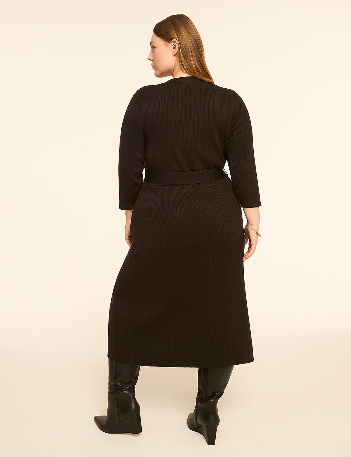 A woman in a black ribbed dress and boots stands against a plain, light-colored background. Product Image 2
