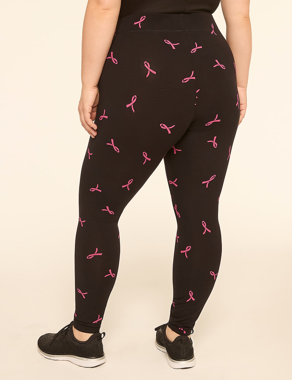 A person wearing black leggings with a pink ribbon pattern stands against a plain, light-colored background. Product Image 2