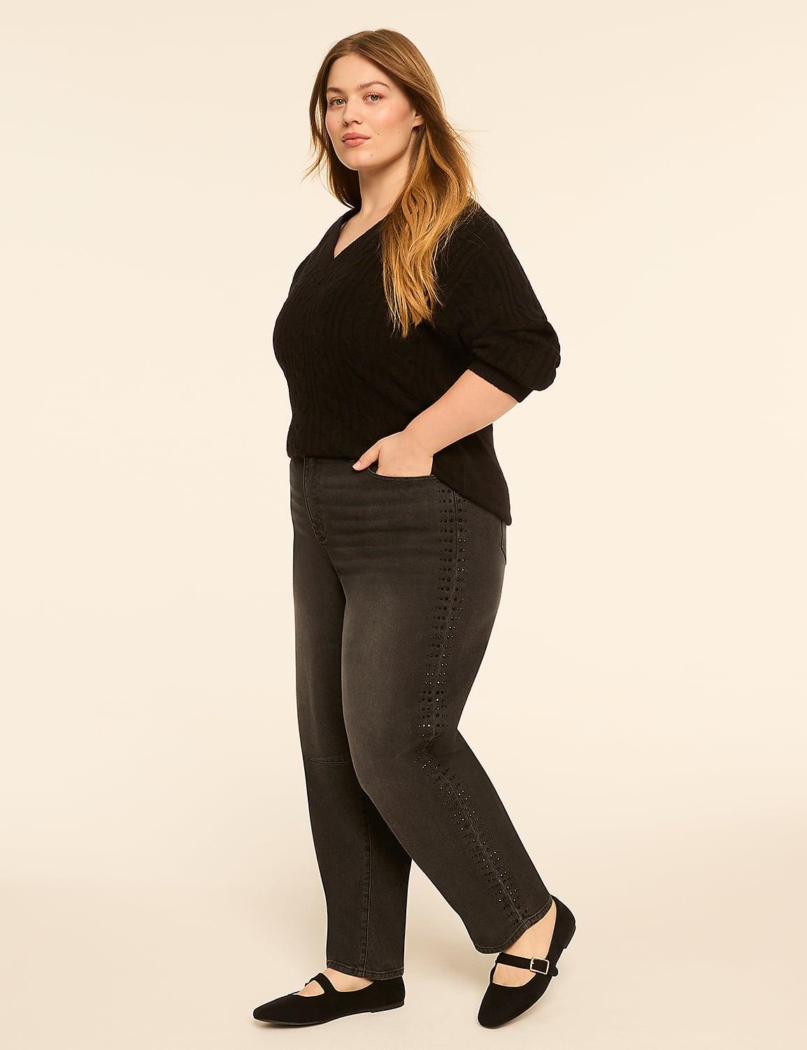 A woman in a black sweater and gray jeans stands with her hand in her pocket against a plain, light-colored background. Product Image 3