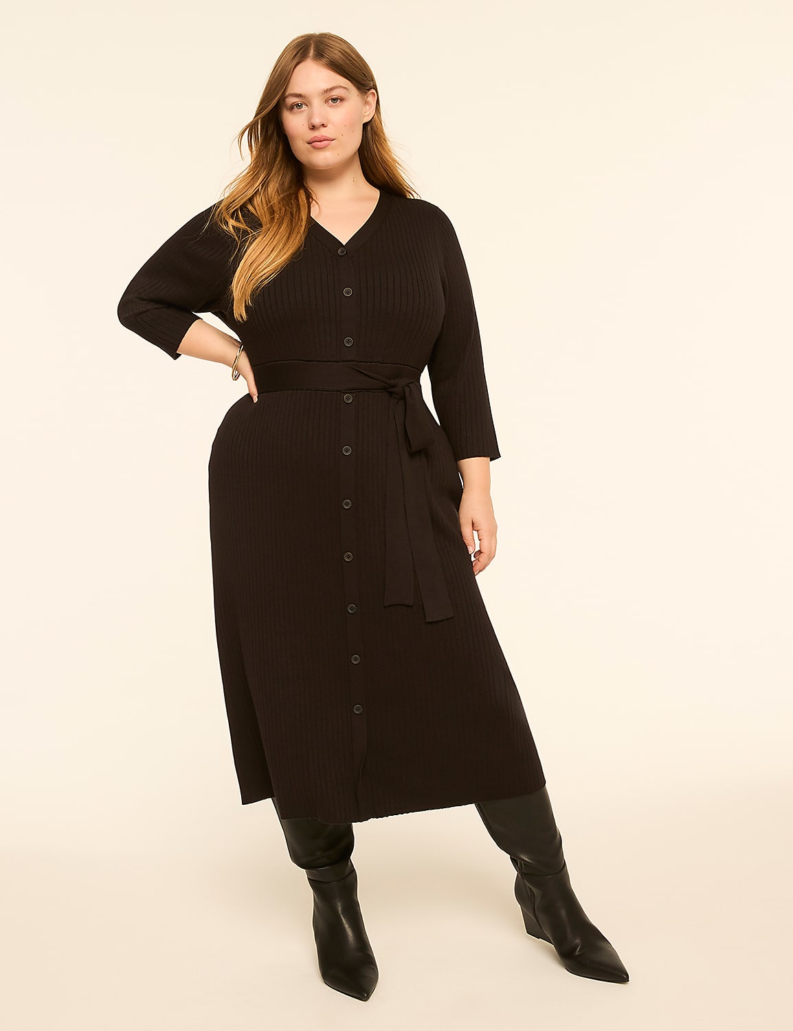 A woman in a black ribbed midi dress and black boots stands against a plain, light-colored background. Product Image 1