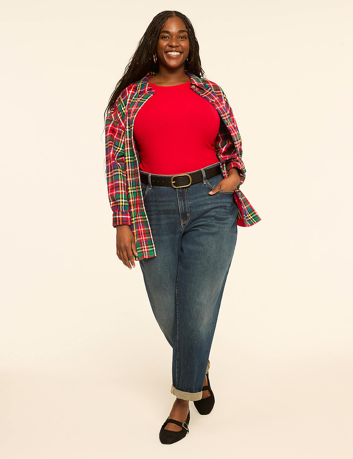 A smiling woman in a red shirt, jeans, and a plaid jacket stands against a plain, light-colored background. Product Image 3
