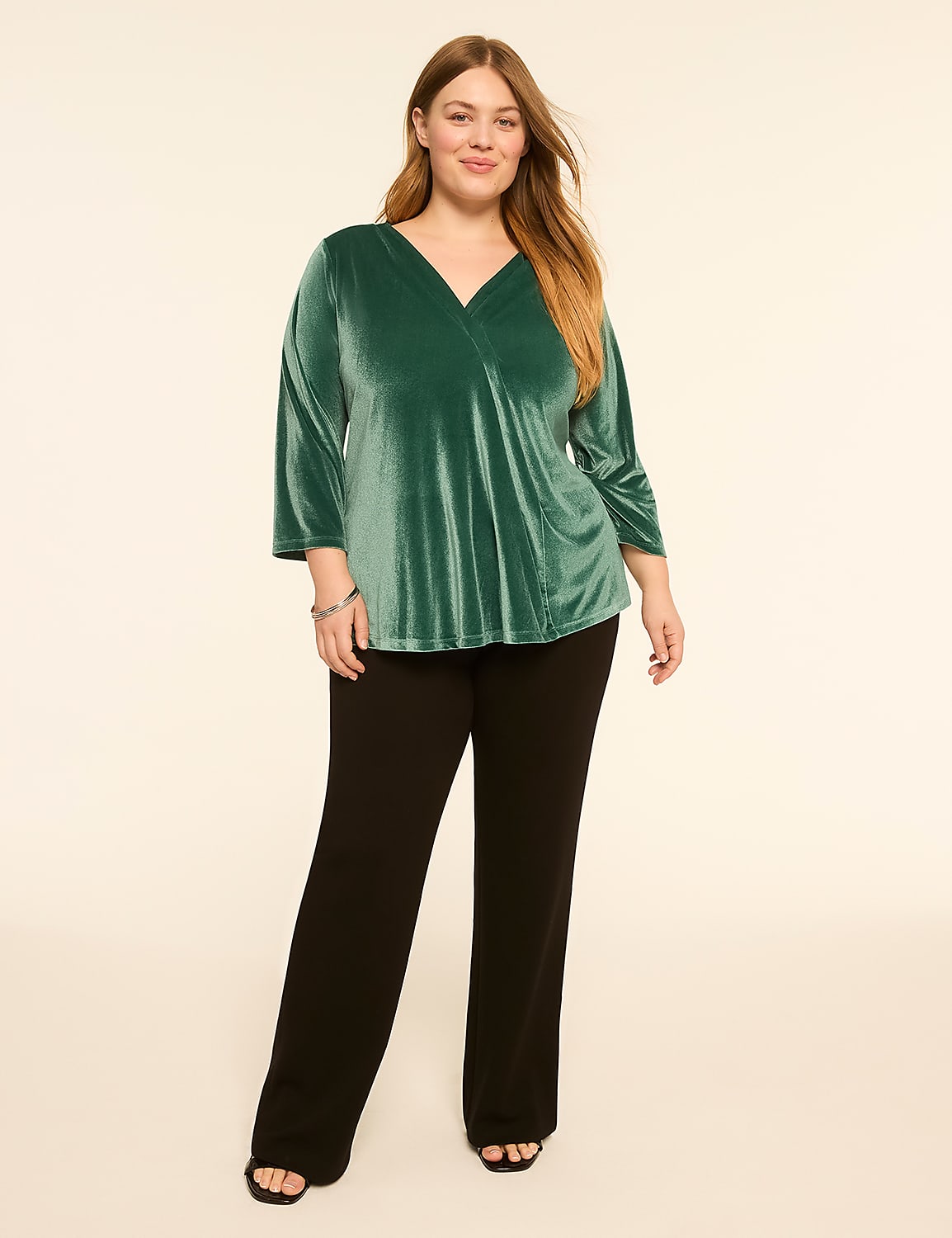 A woman in a green velvet top and black pants stands against a plain, light background. Product Image 3