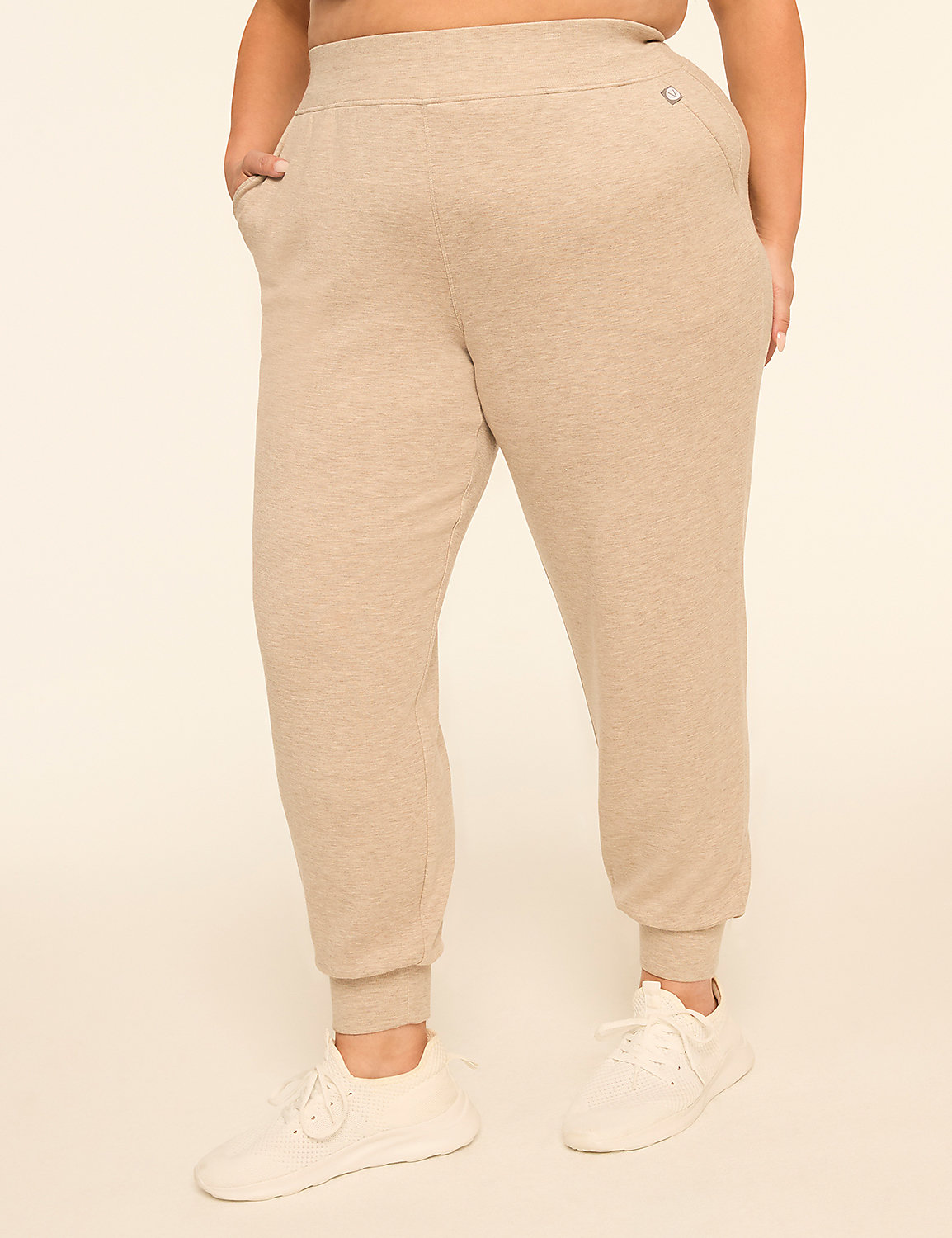 A person wearing beige sweatpants and white sneakers stands against a plain, light-colored background. Product Image 1