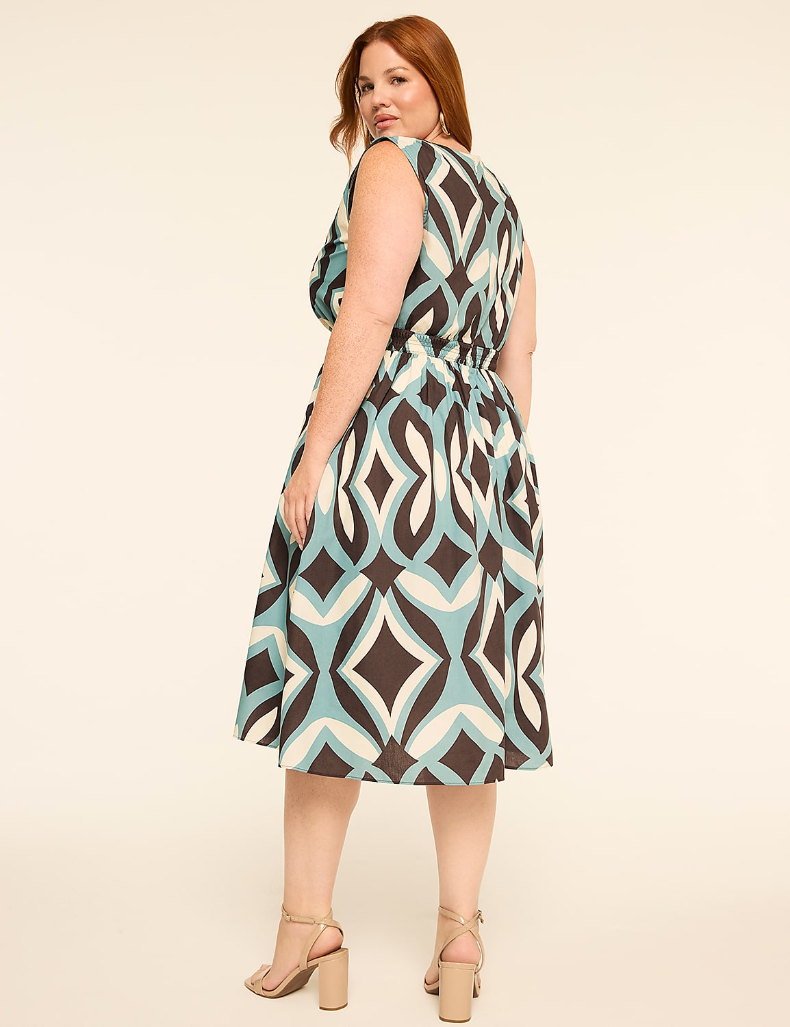 A woman in a patterned dress stands against a plain, light-colored background. Product Image 2