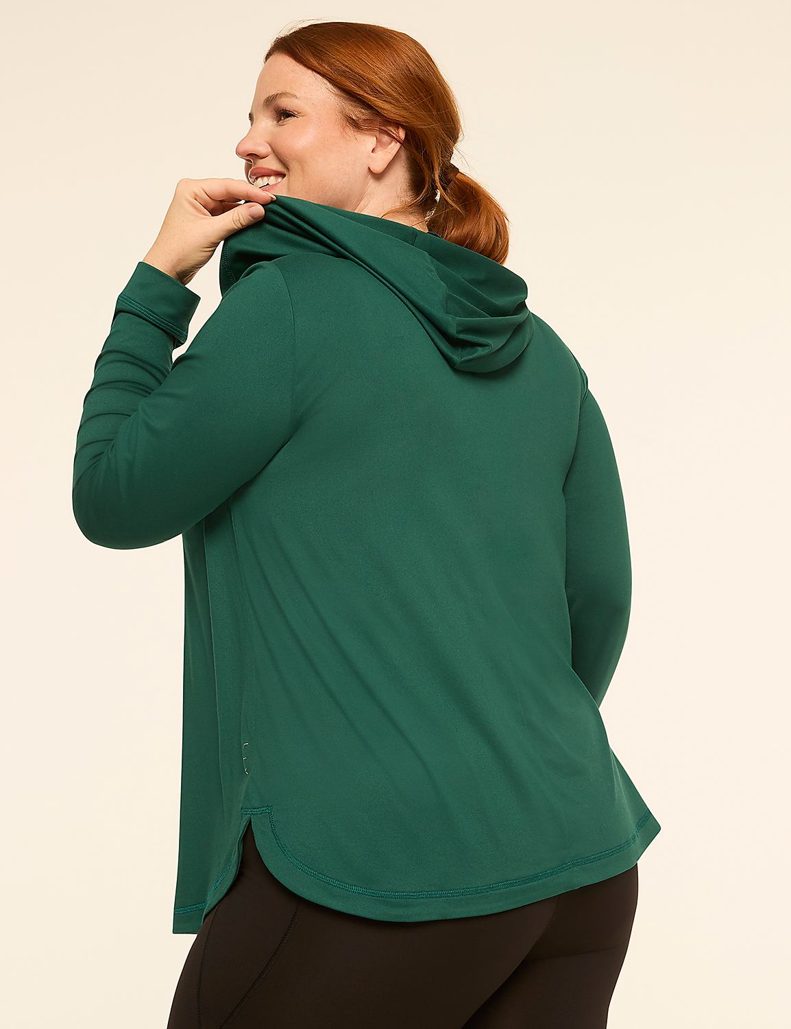 A woman in a green hoodie stands against a plain, light-colored background. Product Image 2