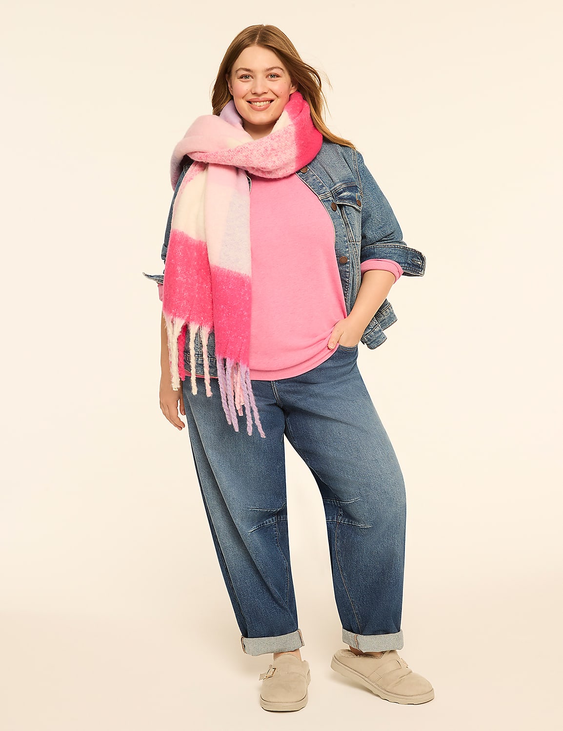 A smiling woman in a pink sweater, denim jacket, and jeans stands against a plain, light-colored background, accessorized with a colorful scarf and clogs. Product Image 3