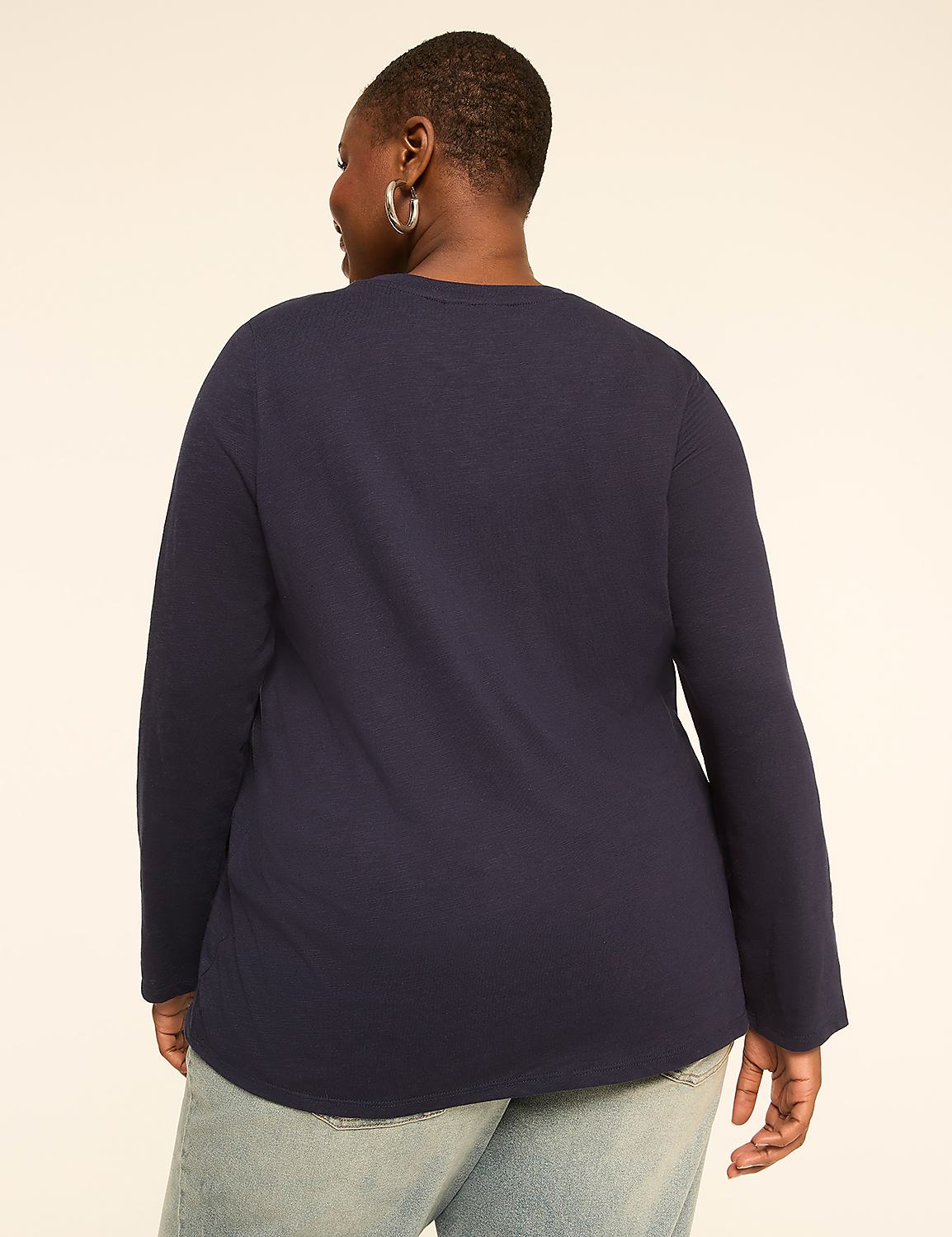 A woman in a navy long-sleeved shirt and light blue jeans stands against a plain, light-colored background. Product Image 2
