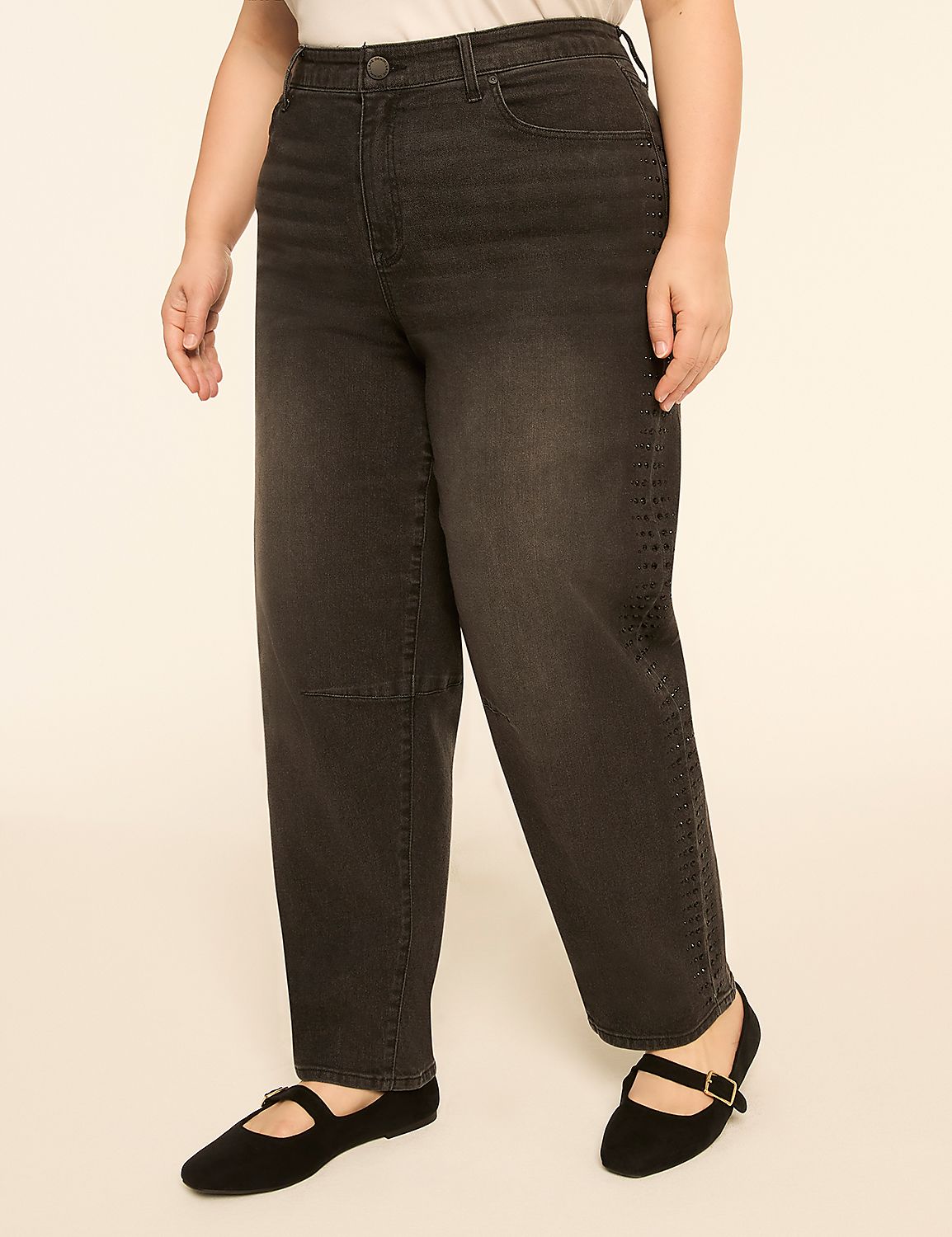 A person wearing dark wash jeans and black ballet flats stands against a plain, light-colored background. Product Image 1