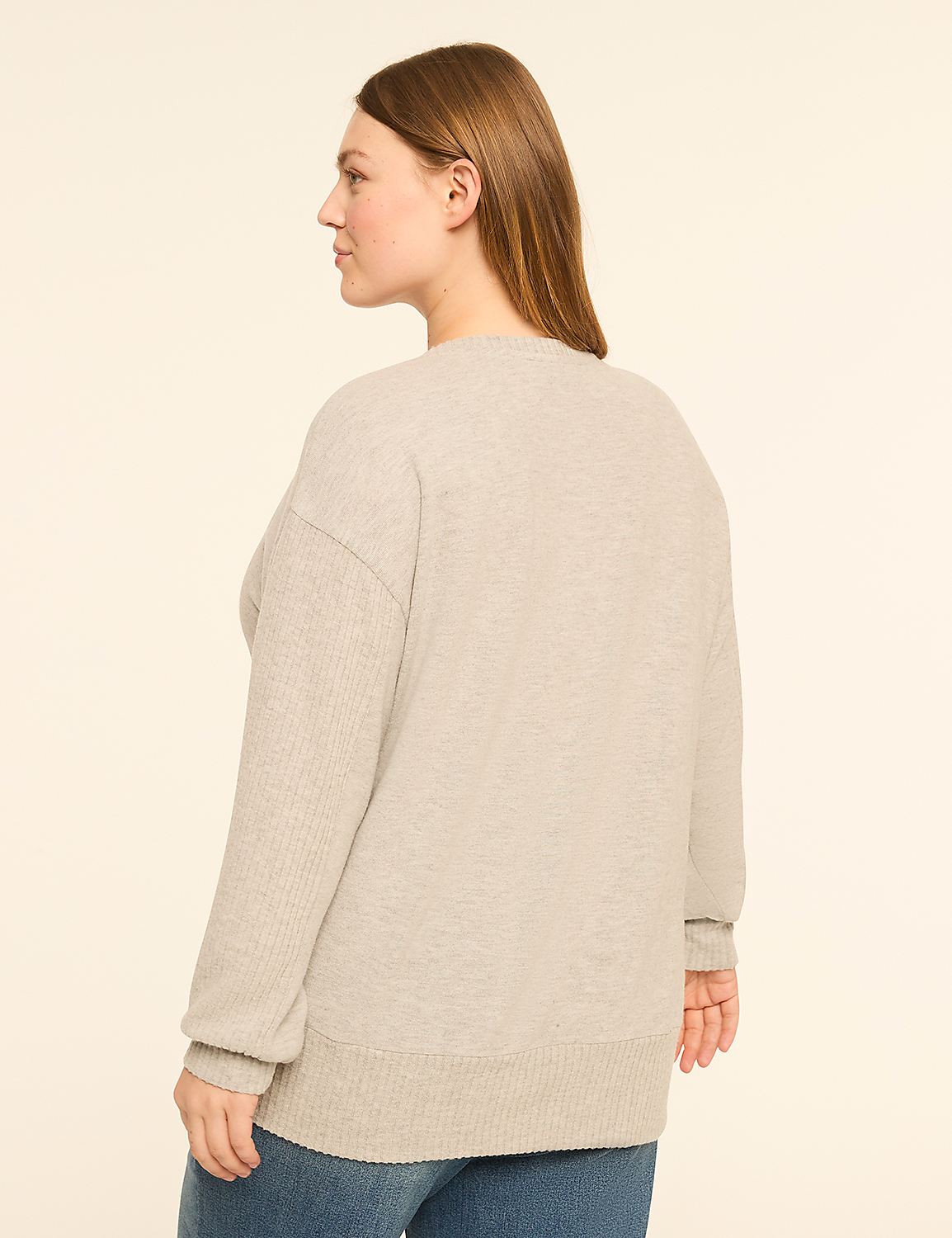 A woman in a light gray sweater and blue jeans stands against a plain, light beige background. Product Image 2