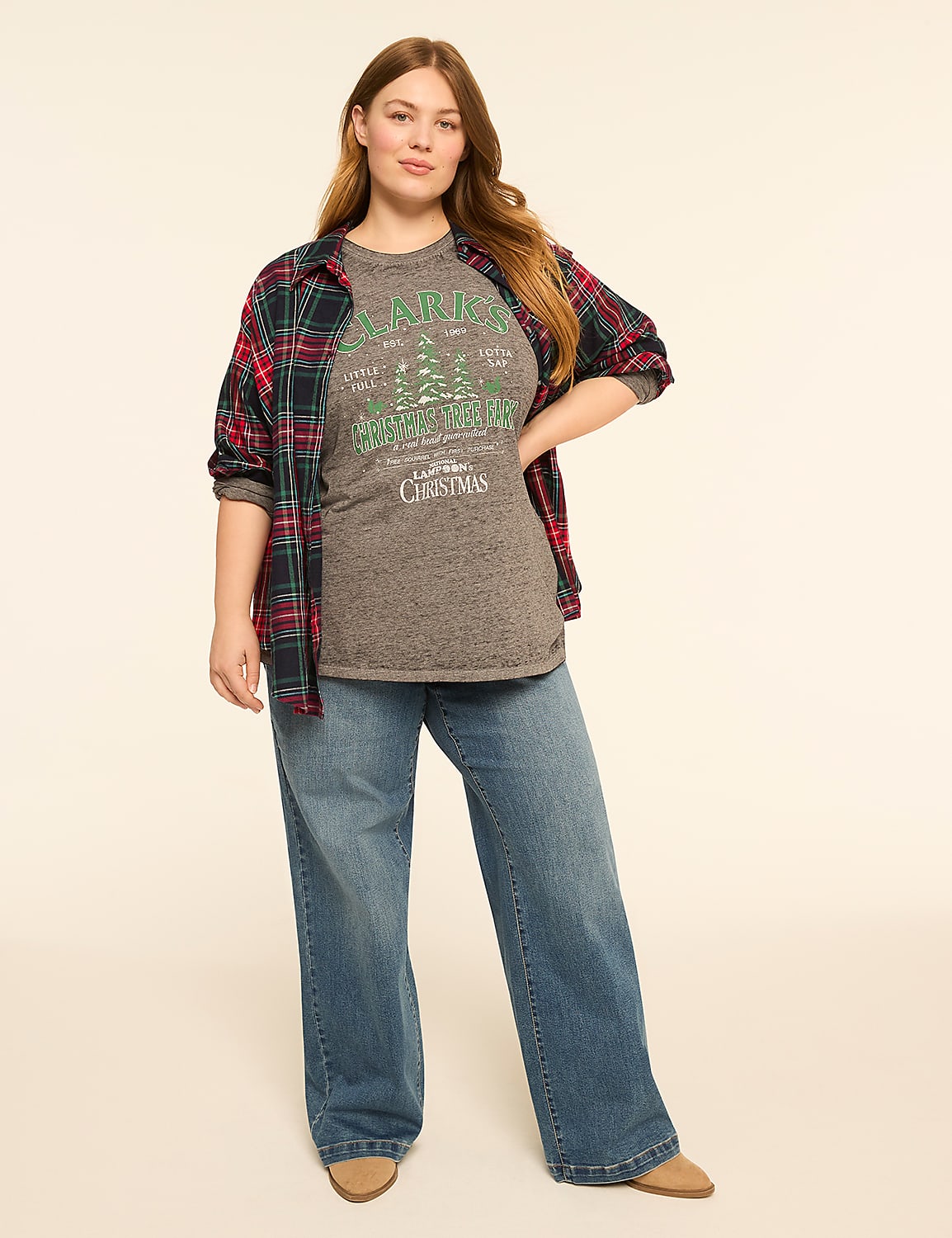 A woman in a graphic t-shirt, open flannel shirt, and wide-leg jeans stands against a plain, light-colored background. Product Image 3