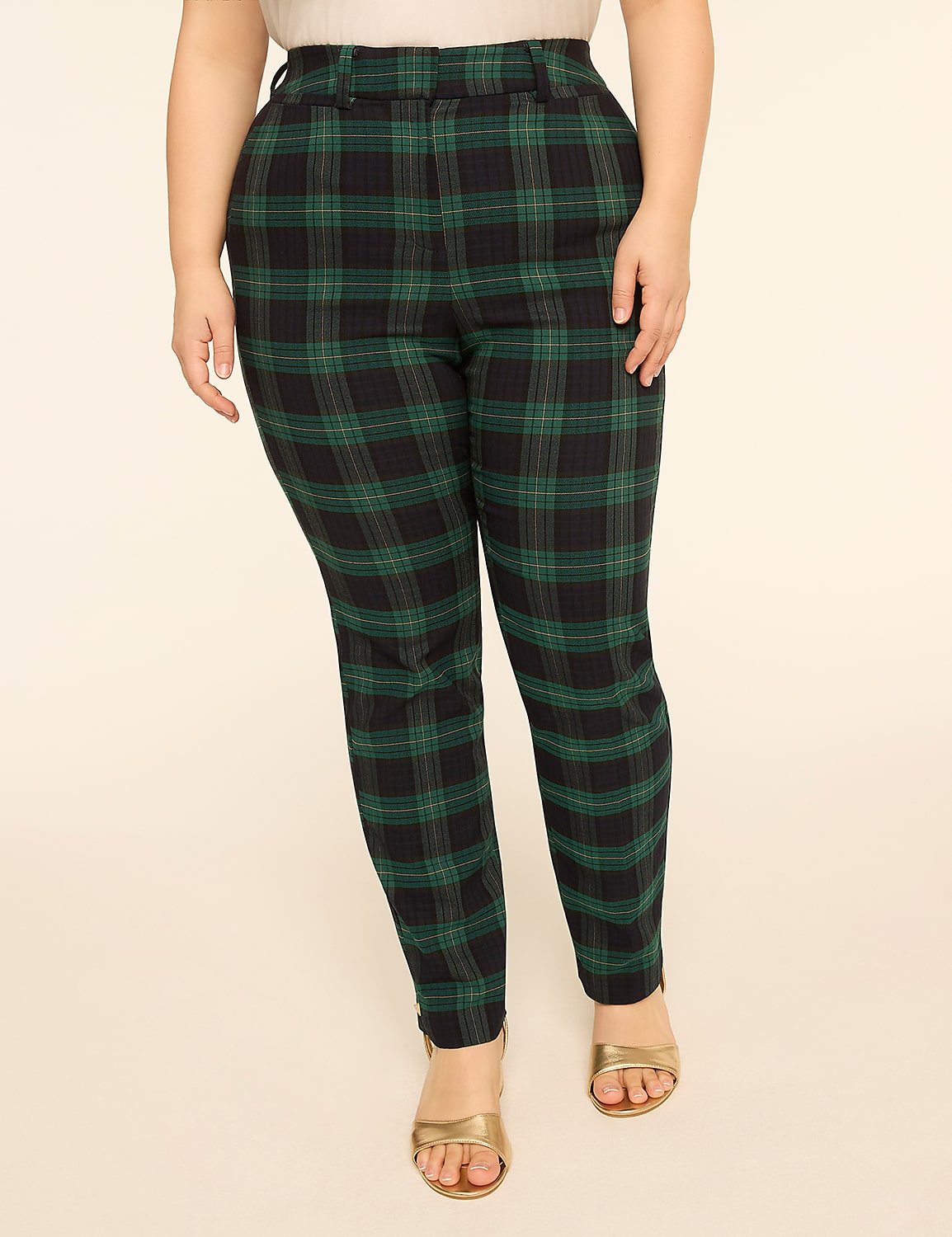 A person stands in the foreground wearing green and black plaid pants and gold sandals, against a plain, light-colored background. Product Image 1