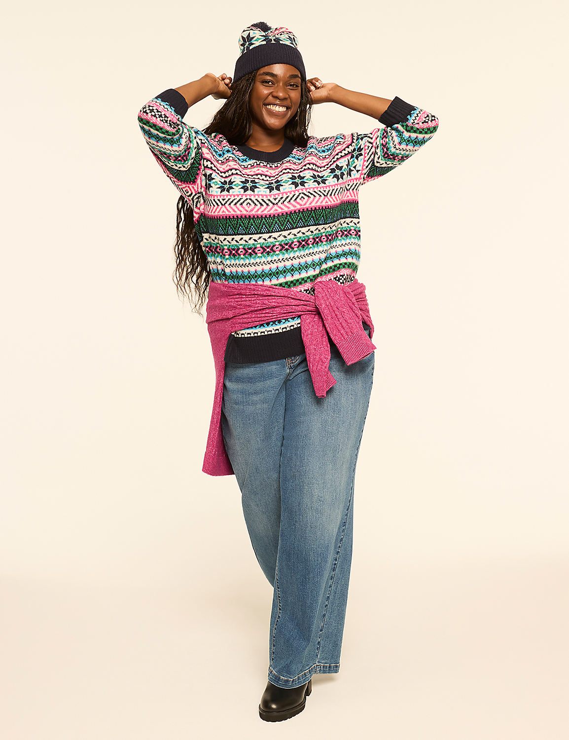 A smiling woman in a patterned sweater and jeans stands against a plain, light-colored background. Product Image 3