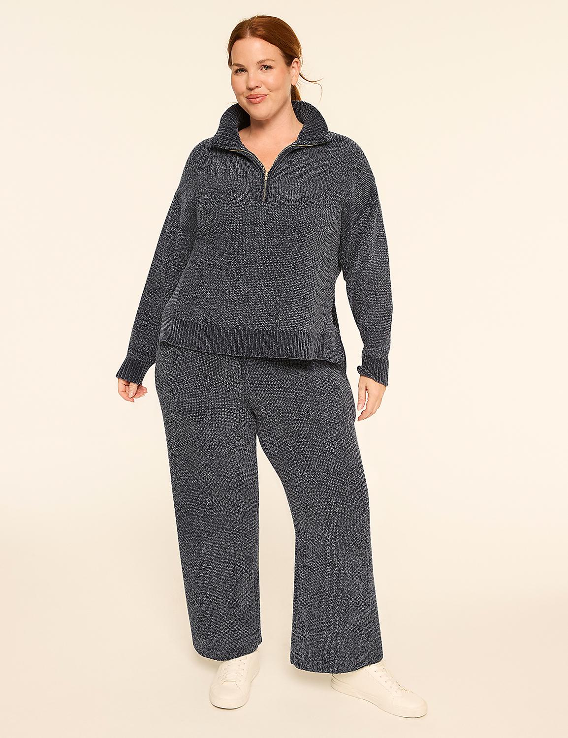 A woman with red hair stands in a cozy, dark blue knit sweater and matching pants against a plain, light background. Product Image 3