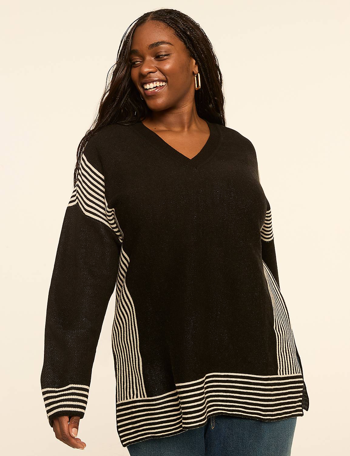 A smiling woman in a black and white striped sweater stands against a plain, light-colored background. Product Image 1