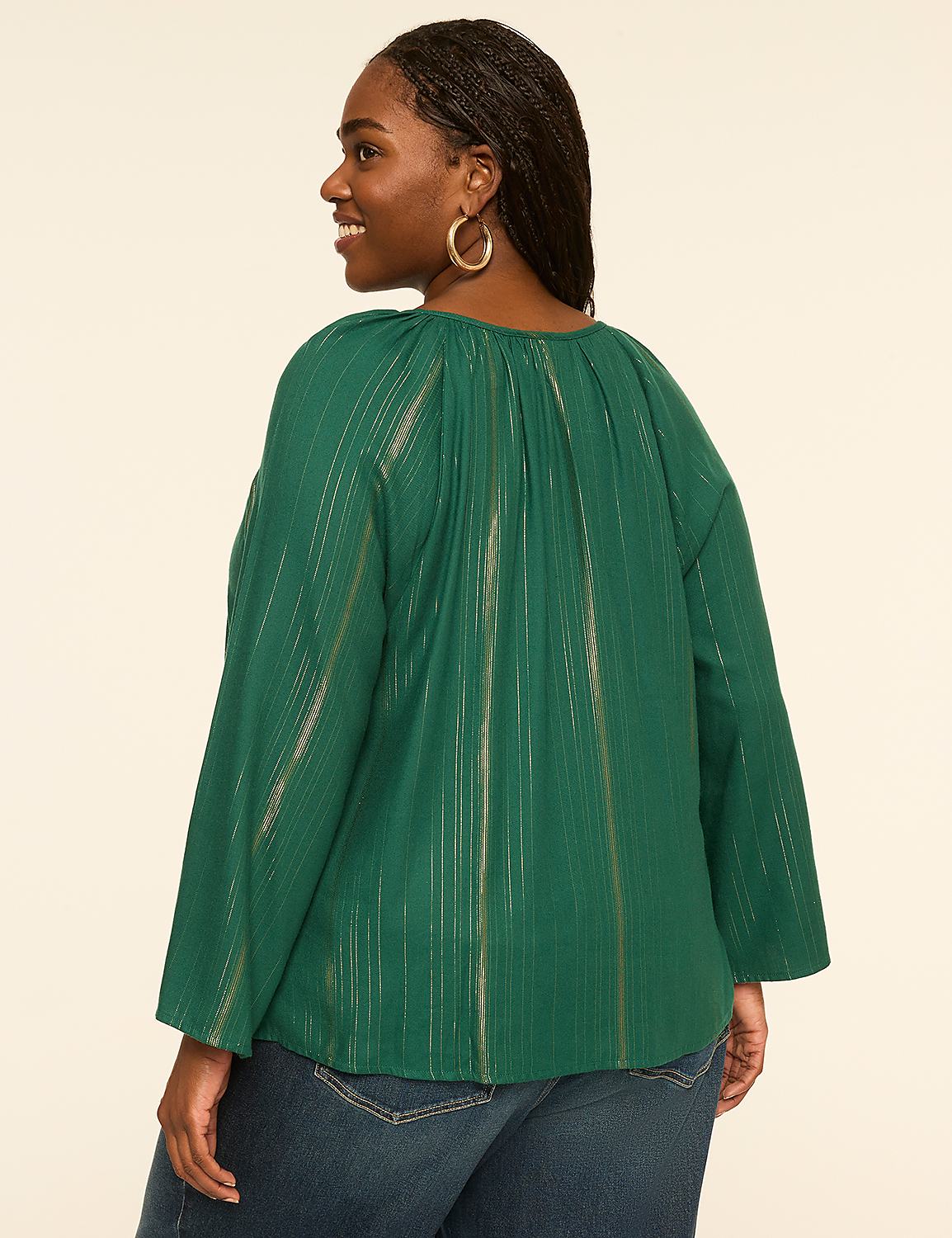 A woman in a green, metallic-striped blouse and blue jeans stands against a plain, light-colored background. Product Image 2