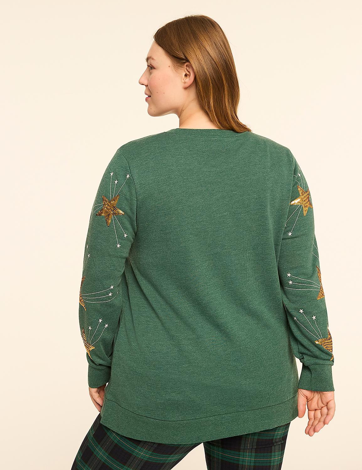 A woman in a green sweater with gold star embellishments on the sleeves stands against a plain, light-colored background. Product Image 2