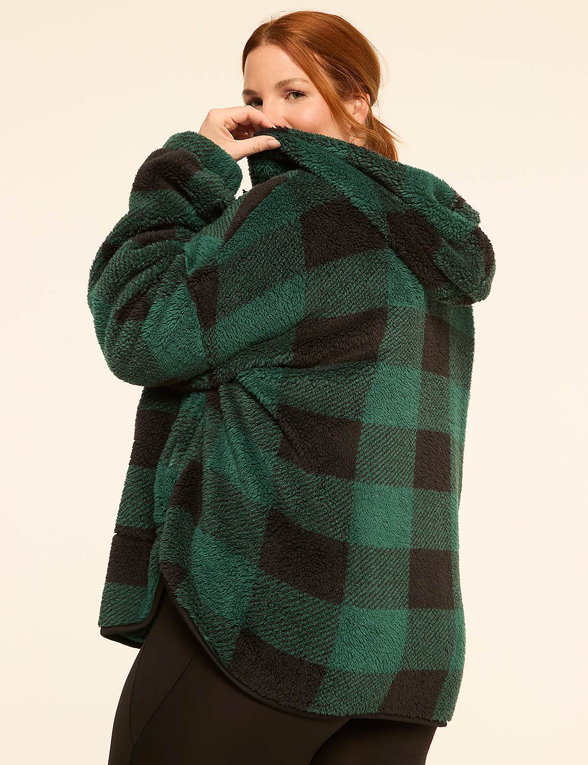 A woman in a green and black plaid fuzzy jacket peeks over her shoulder against a plain cream background. Product Image 2