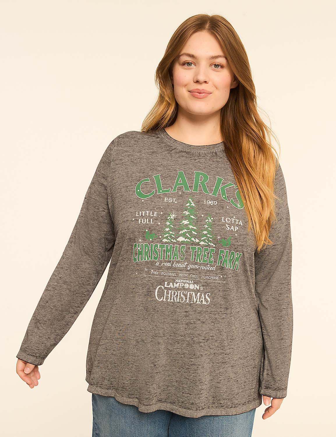 A woman in a gray long-sleeved shirt with a Christmas tree farm graphic stands against a plain, light-colored background. Product Image 1