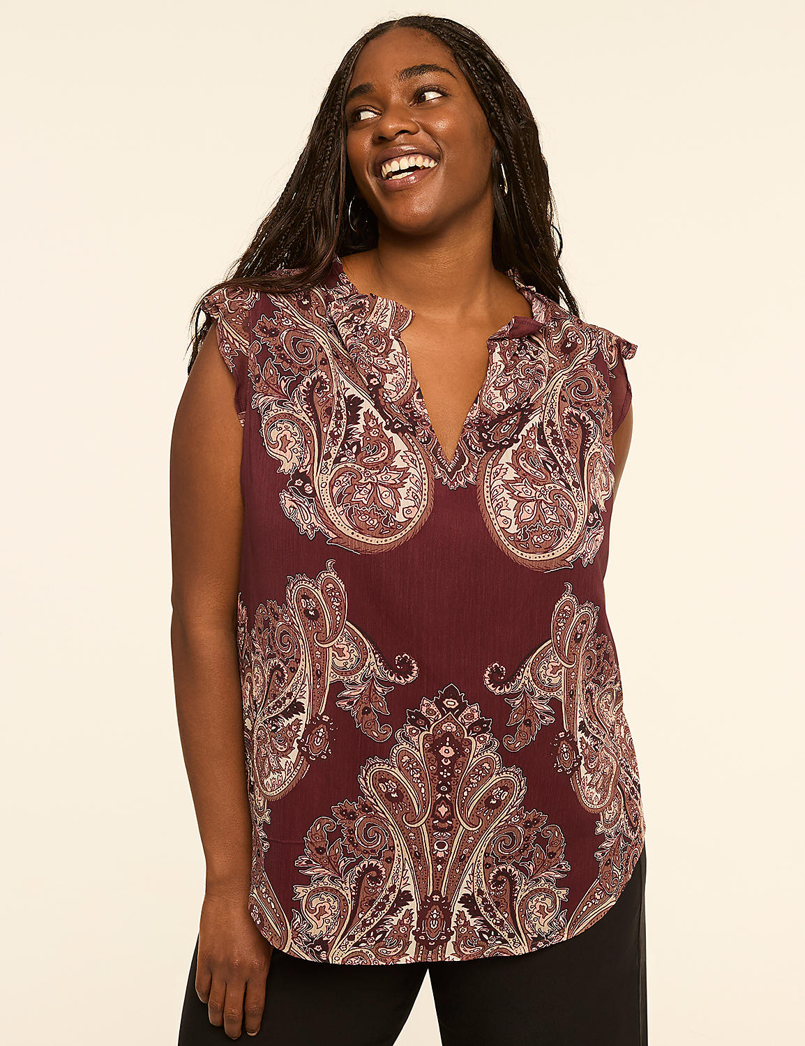 A smiling woman in a paisley-patterned burgundy blouse stands against a plain, light-colored background. Product Image 1