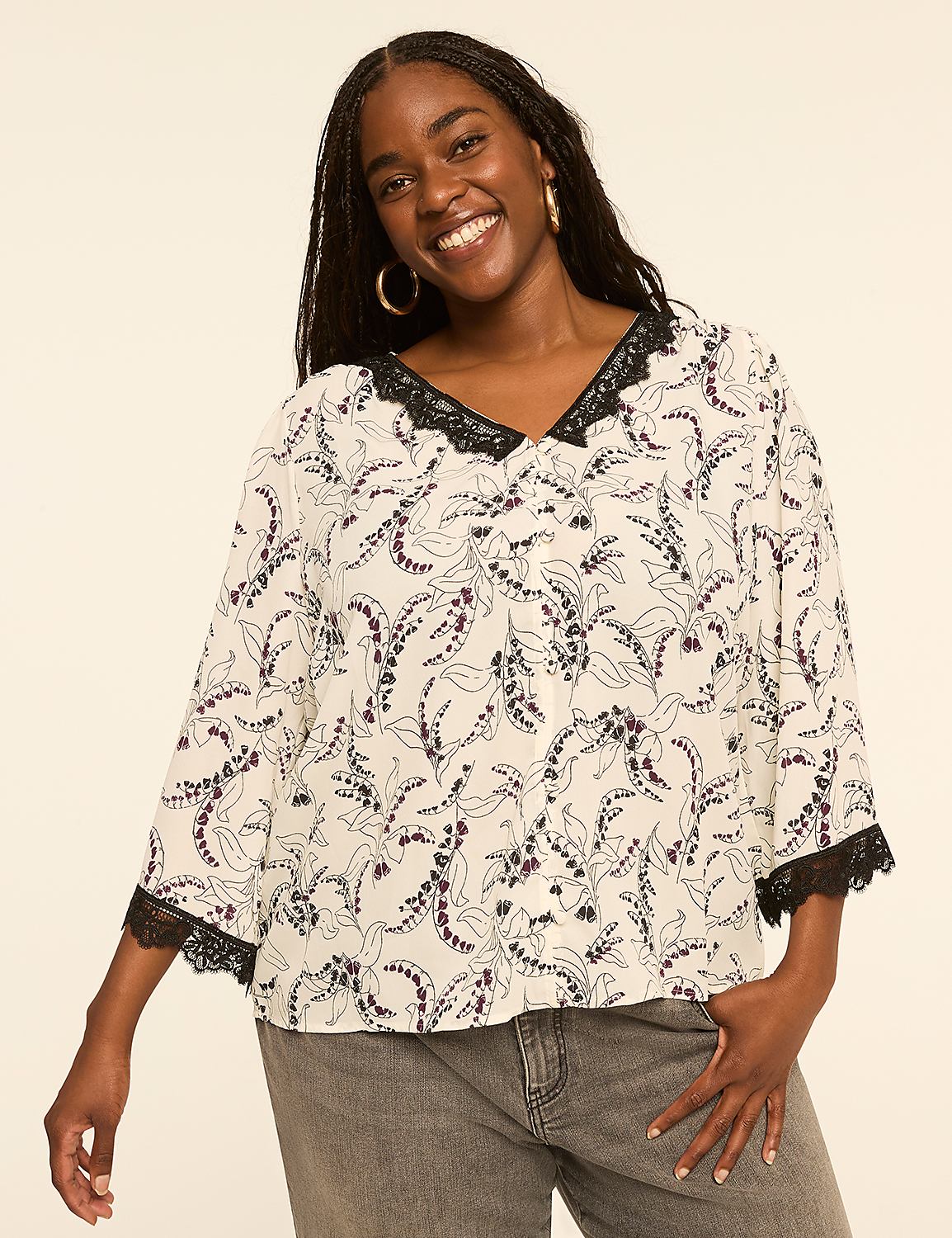 A smiling woman in a floral blouse stands against a plain, light-colored background. Product Image 1