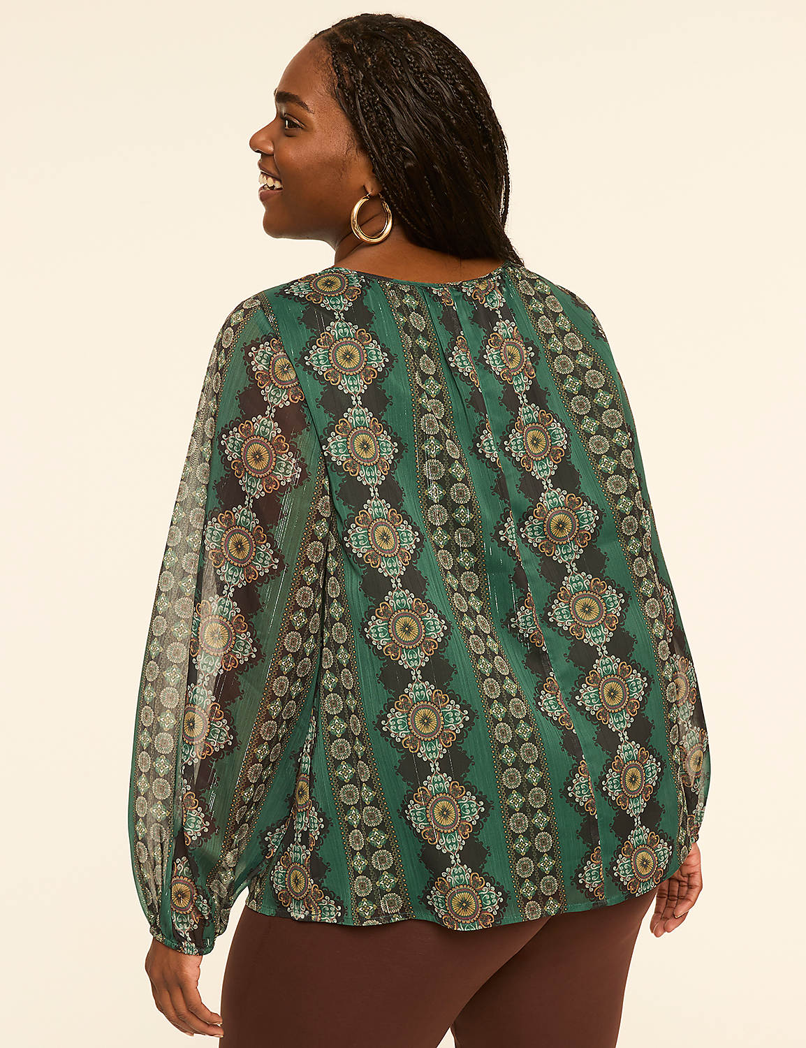 A woman in a patterned green blouse stands against a plain, light-colored background. Product Image 2