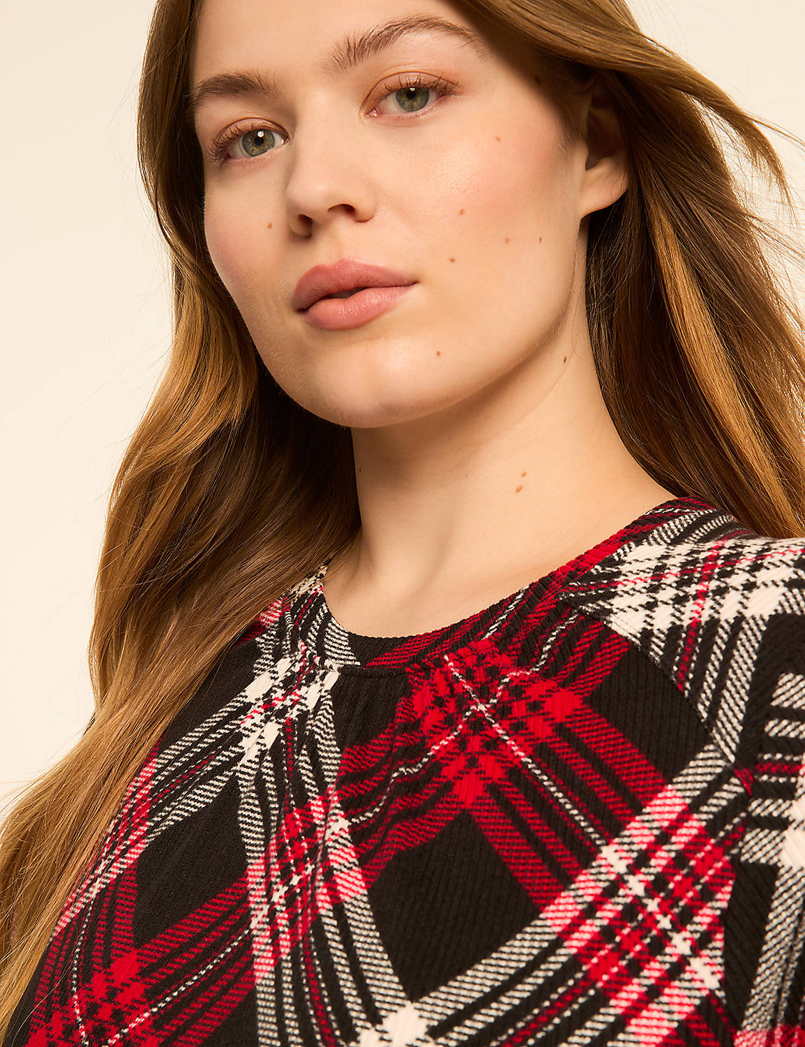 A woman with long, blonde hair wears a red, black, and white plaid top against a plain, light-colored background. Product Image 4