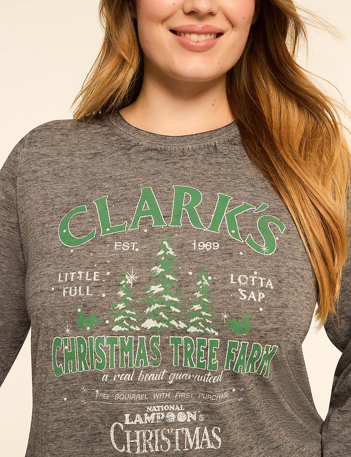 A woman in a gray long-sleeved shirt with a "Clark's Christmas Tree Farm" graphic stands against a plain background. Product Image 4
