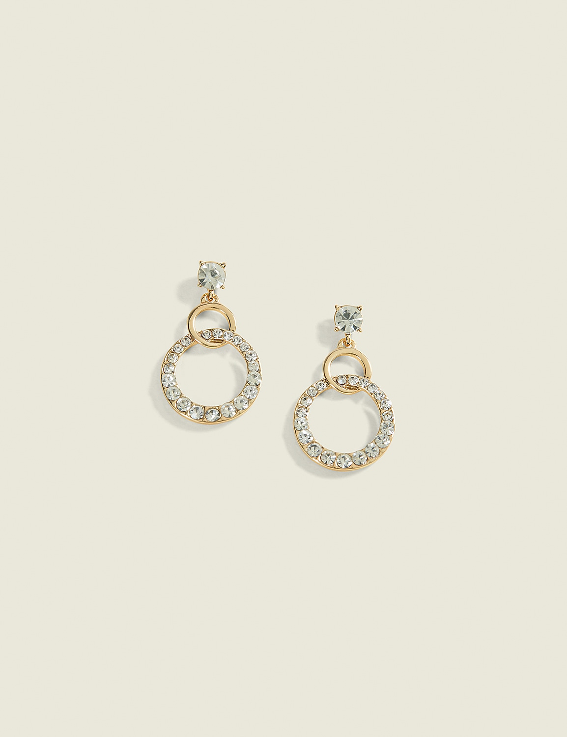 A pair of gold hoop earrings encrusted with clear rhinestones dangle against a soft, muted beige background. Product Image 1
