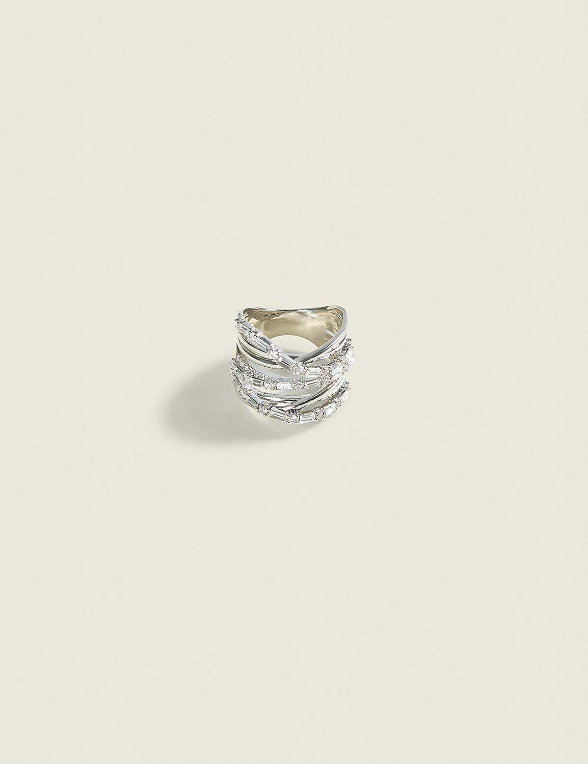 A detailed silver ring with multiple bands and sparkling stones rests on a plain, light-colored background. Product Image 1