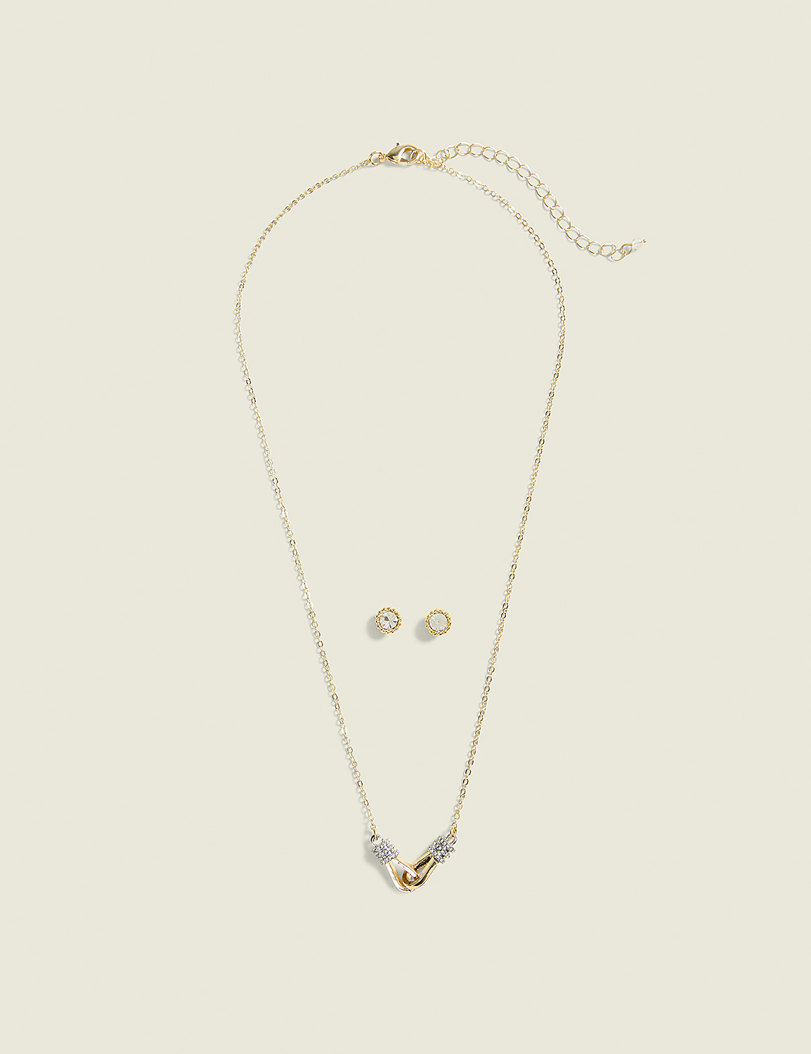 A gold necklace with a pendant and matching stud earrings are laid out on a plain, light-colored background. Product Image 1